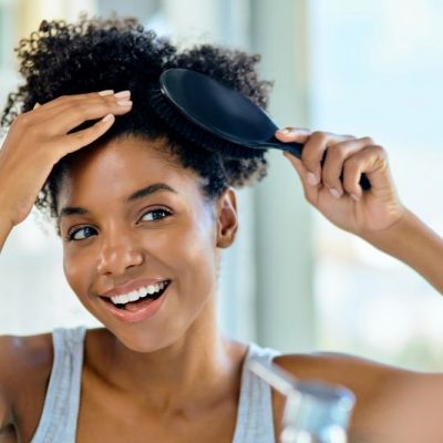 Smiling Woman Brushing Homemade Dry Shampoo into Her Hair