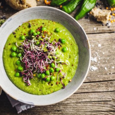 Vegan Split Pea Soup with Leeks in Round Bowl on Outdoorsy Wooden Table Top