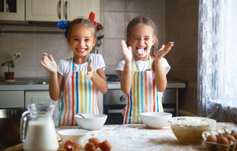 Smiling Girls Baking Cookies in Kitchen as Part of Fun Summer Activities Plans