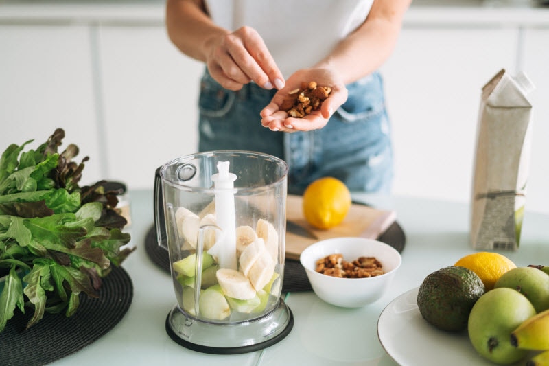 Person Making Fruit and Nut Smoothie to Represent Concept of Benefits of Plant Based Protein