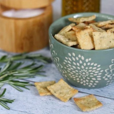 Olive Oil & Rosemary Homemade Crackers in Blue Snack Bowl Next to Salt Cellar and Sprogs of Rosemary
