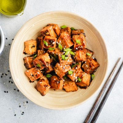 Marinated Sesame Tofu in Japanese Bowl Next to a Bowl of Soy Sauce Marinade Sprinkled with Sesame Seeds
