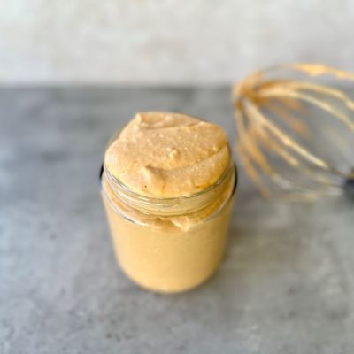 Pumpkin Coconut Milk Whipped Cream in Glass Jar Next to Wire Mixer Head from Stand Mixer on Gray Counter