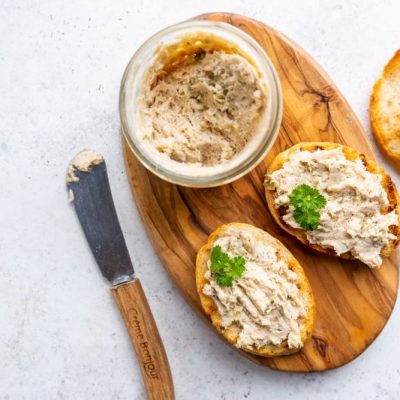 Smoked Salmon Pate in Serving Bowl on Oval Wooden Serving Board with Crusty Sliced Bread