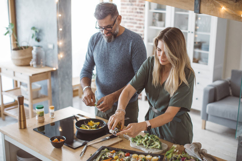 Couple Preparing Holiday Dinner in Kitchen Questioning What to Serve Vegan Guests