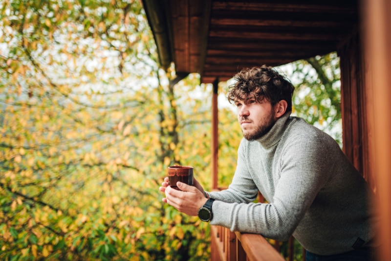 Man Looking Into Distance Holding Cup of Coffee