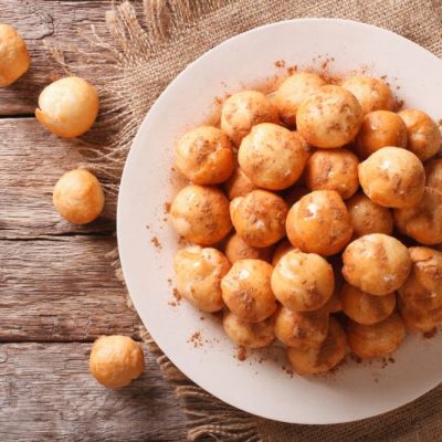 Hanukkah Doughnut Holes (Gluten-Free) Drizzled with Honey on Round White Plate