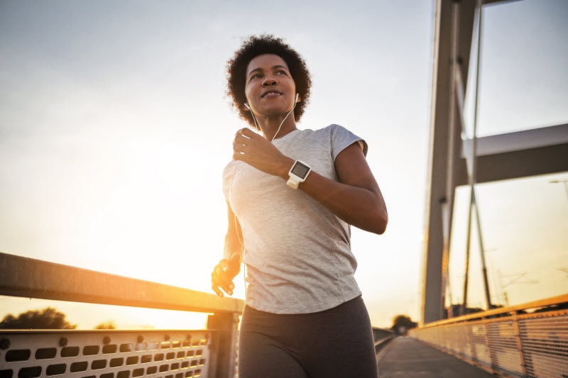 Woman Following Cardiovascular Fitness Plan Taking Early-Morning Run 