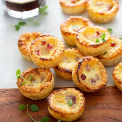 Gluten-Free Ham & Cheese Mini Quiches Arranged with Micro-Greens on a Charcuterie Board