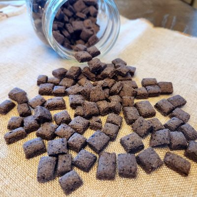 A Mason Jar Spills Homemade Dog Training Treats onto a Countertop.
