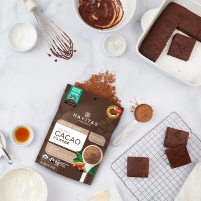 Navitas Cacao Powder Featured on Countertop With Brownies and Assorted Ingredients and Mixing Utensils