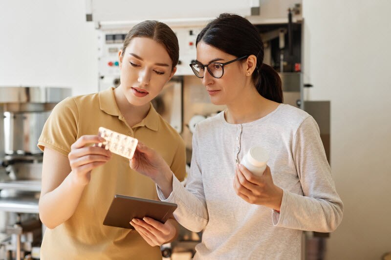 Two Women in Kitchen Looking at Supplement Package to Determine Probiotic Facts