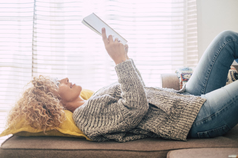 Plasmalogens and Brain Health Concept Represented by Middle-Aged Woman Reading Book on Couch