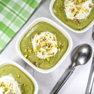 Homemade Vegan Pistachio Pudding in Square White Bowls Topped with Coconut Whipped Cream & Crushed Pistachios
