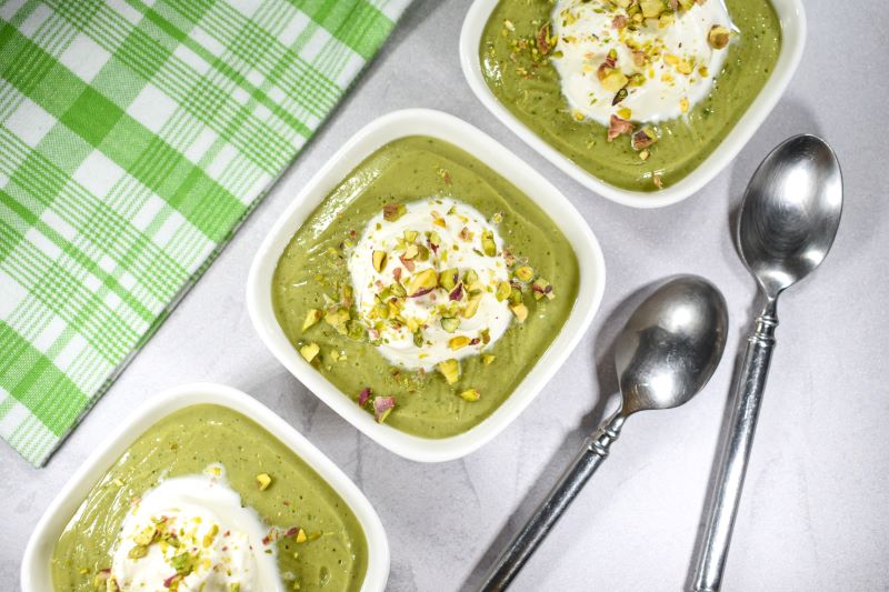 Homemade Vegan Pistachio Pudding in Square White Bowls Topped with Coconut Whipped Cream & Crushed Pistachios