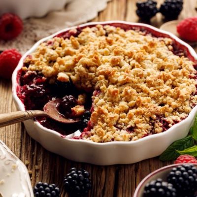 Blackberry Crumble in White Baking Dish on Wooden Table Top