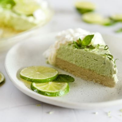 Slice of No-Bake Avocado Key Lime Pie Recipe on White Plate with Lime Slices