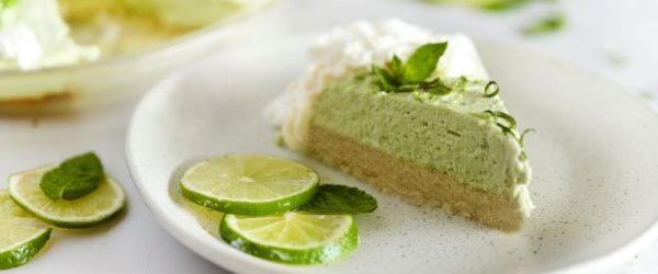 Slice of No-Bake Avocado Key Lime Pie Recipe on White Plate with Lime Slices