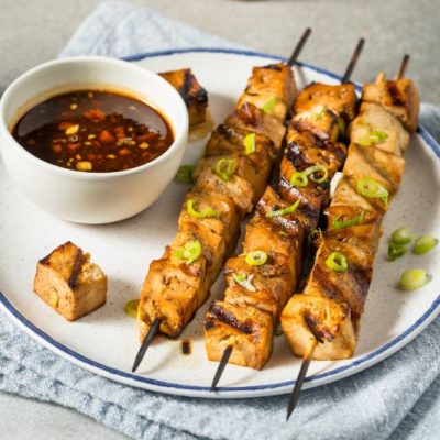 Grilled Tofu Skewers on a Plate With a Bowl of Chipotle Dipping Sauce