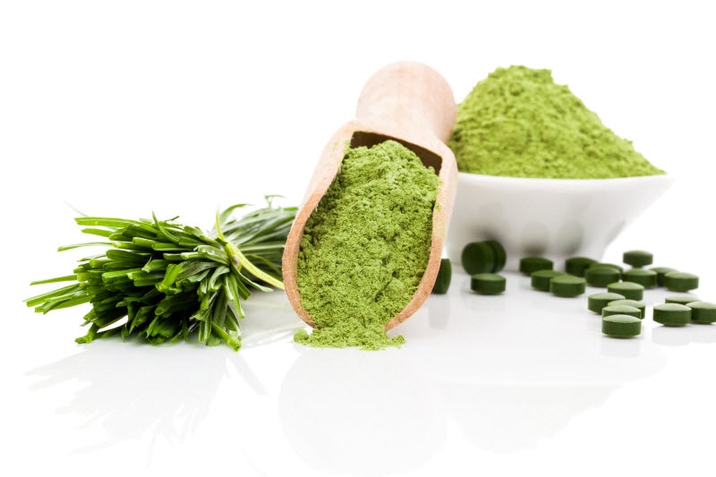 Vibrant Green Spirulina Powder, Fresh Plant and Tablets on White Surface