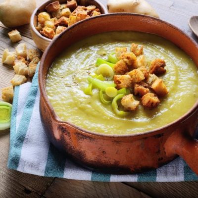 Potato-Leek Soup with Croutons in Soup Tureen on Rustic Wood Table Top
