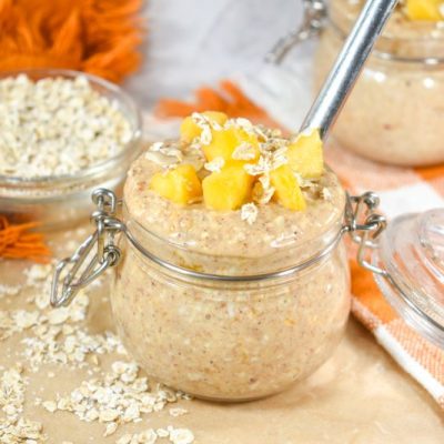 Overnight Oats Recipe Made with Peaches and Almonds on Small Lidded Mason Jar on Countertop
