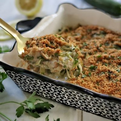 A Gold Serving Spoon Scoops a Hearty Helping of Creamy Tuna Zucchini Casserole.
