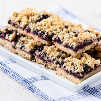 Blueberry Pie Bars on White Tray With Towel Underneath