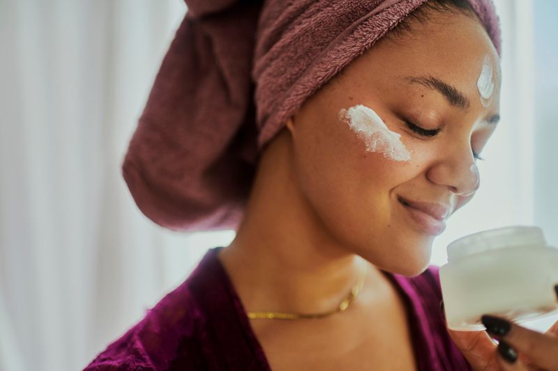 Woman With Cream on Face Trying to Diminish the Look of Sunspots on Skin