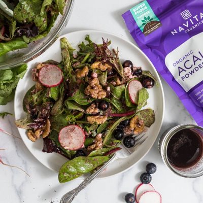An Overhead View of a Salad With Acai Vinaigrette With Greens and Berries.