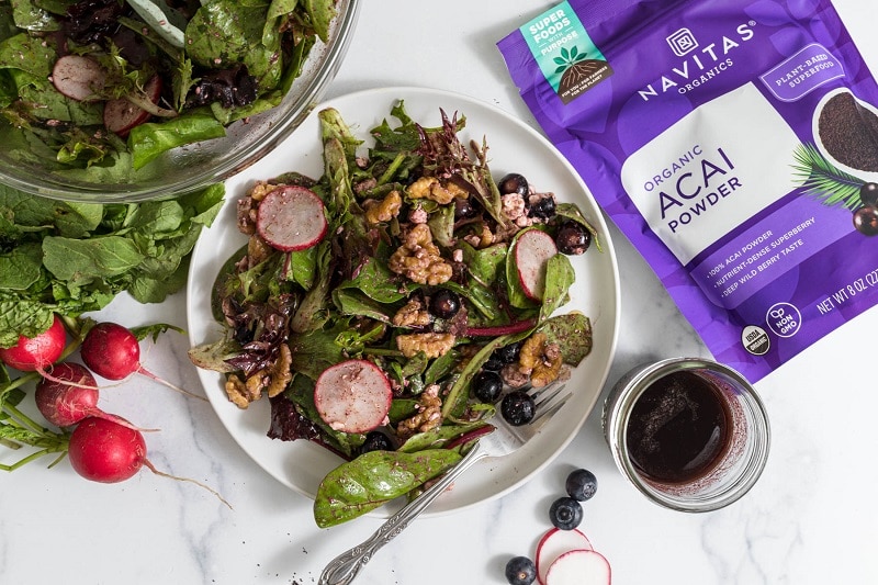 An Overhead View of a Salad With Acai Vinaigrette With Greens and Berries.