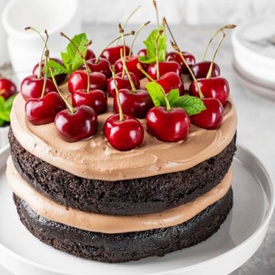 Black Forest Layer Cake Topped With Cherries on Round Serving Platter
