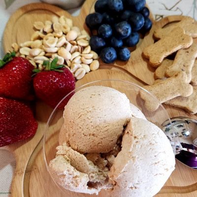 A Paw-Shaped Wooden Serving Board Holds Berries, Dog Treats, Peanuts and a Puppy Parfait.