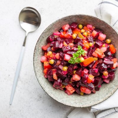 Roasted Beet Salad with Corn, Carrot and Celery in Earthenware Bowl on Counter