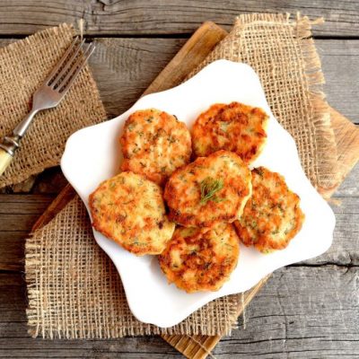 Fried Salmon Patties on Square Plate Set On Burlap and a Wooden Cutting Board Atop a Rustic Wooden Surface