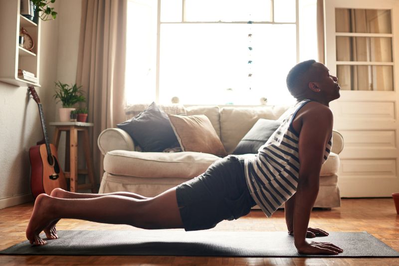 Person Practicing Yoga for Diabetes Management in Living Room