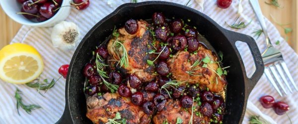 Cherry Chicken in a Cast Iron Skillet Surrounded by Fresh Ingredients