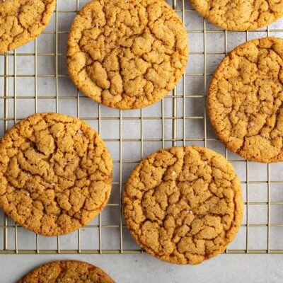 Chewy Molasses Cookies Spread Out on a Gold Wire Cooling Rack