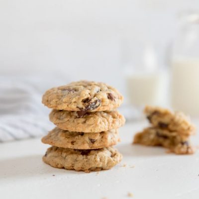 Coconut & Chocolate Chip Oatmeal Raisin Cookies with Einkorn Flour on Soft White Counter with a Container of Milk in the Background