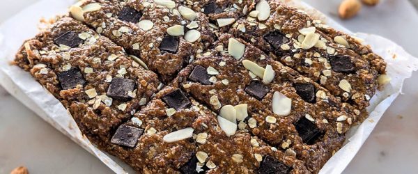 A Batch of No-Bake Protein Bars Sit in a Pan. They're Made With Oats, Chocolate Chunks and Nuts.