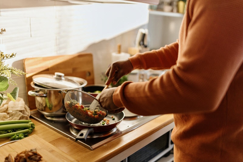 Torso View of Person Cooking Healthy Meal at Stove to Represent Protein and Diabetes Concept