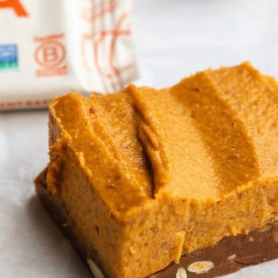 A Close-Up Shows a Vegan Pumpkin Bar With an Aloha Pumpkin Spice Protein Bar as a Base.