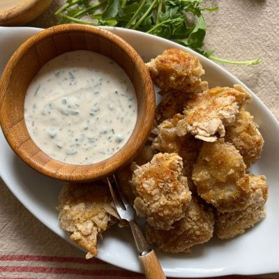 Breaded Chicken Bites Sit in a White Serving Bowl With a Side of Homemade Ranch Dressing Dip.