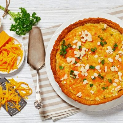 A Butternut Squash Dinner Pie is Topped With Slivered Almonds and Fresh Parsley.