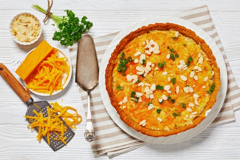 A Butternut Squash Dinner Pie is Topped With Slivered Almonds and Fresh Parsley.