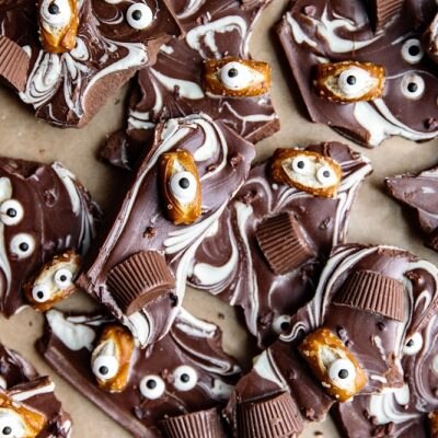 Swirled White and Dark Chocolate Halloween Bark is Topped With Candy Eyes, Pretzels and Peanut Butter Cups.