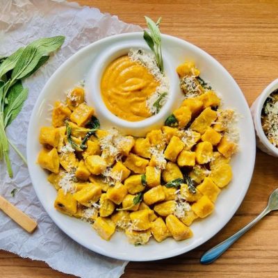 Mini Pumpkin Gnocchi with Sage Butter on a Serving Plate with Pumpkin Cream Sauce in a Dipping Bowl