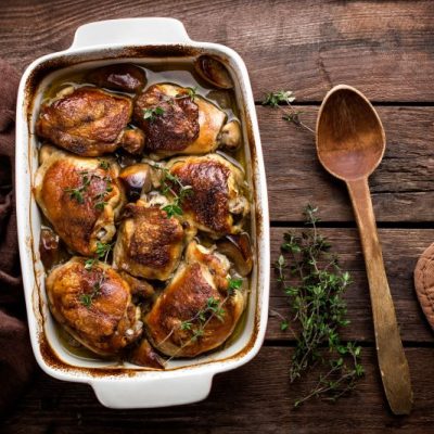Rustic One-Pan Chicken & Potatoes in White Baking Pan Resting on Dark Wood Surface