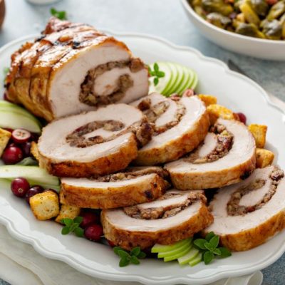Apple, Walnut & Cranberry Stuffed Pork Loin Cut into Slices on Serving Platter