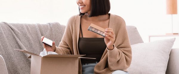 Smiling Woman Unboxing a Haul of Clean Beauty Brands Products Delivered in a Brown Box